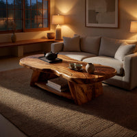 Figured wood free form coffee table with a lower shelf in an evening room lit by two lamps