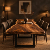 Long wood tabletop with uneven natural edges and bold swirling grain in a dark dining room at golden hour