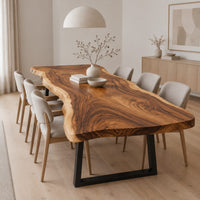 Long wood tabletop with uneven natural edges and bold swirling grain in a Scandinavian dining room with white walls