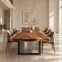 Long wood tabletop with uneven natural edges and bold swirling grain in a bright open plan dining room