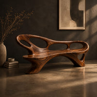 Long freeform bench with oval cutouts along the back and flared legs, three-quarter view showing the grain