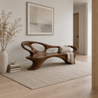 Long freeform bench with oval cutouts along the back and flared legs in a Scandinavian entryway with white walls