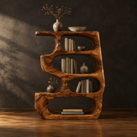Freeform bookshelf with four stacked oval openings and a thick wavy outline in a dark studio against a charcoal plaster wall