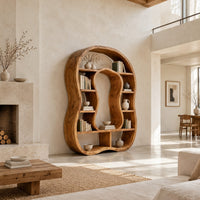 Freeform bookshelf with a keyhole shaped center opening and uneven shelves in a bright open plan living room