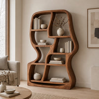 Freeform wooden bookshelf with uneven open cubbies and a soft outline in a Scandinavian living room with white walls
