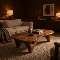 Freeform coffee table with a smooth organic top on sculpted arched legs in an evening living room with walnut wall paneling