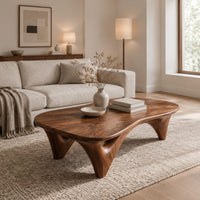 Freeform coffee table with a smooth organic top on sculpted arched legs in a Scandinavian living room with white walls