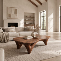 Freeform coffee table with a smooth organic top on sculpted arched legs in a bright open plan living room