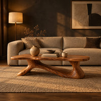 Freeform wooden coffee table with a sculpted branching base in a dark living room at golden hour