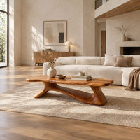 Freeform wooden coffee table with a sculpted branching base in a bright open plan living room