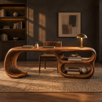 Freeform loop desk with a swooping end and stacked oval shelves in a dark home office at golden hour
