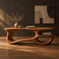 Freeform oval desk with an open loop base and a low shelf in a dark studio against a charcoal plaster wall