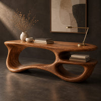 Corner detail of freeform oval desk with an open loop base and a low shelf beside wood, brass and linen samples