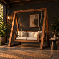 Freestanding a frame swing with a cushioned bench seat on chains in a dark porch at golden hour