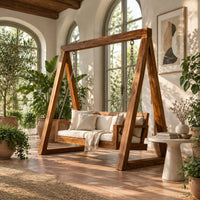 Freestanding a frame swing with a cushioned bench seat on chains in a bright porch with arched windows and plants