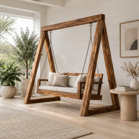 Freestanding a frame swing with a cushioned bench seat on chains in a Scandinavian porch with white walls