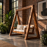Freestanding a frame swing with a cushioned bench seat on chains in an industrial loft porch with exposed brick