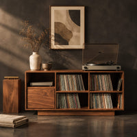 Corner detail of low cabinet with a grid of open cubbies and a slim plinth base beside wood, brass and linen samples