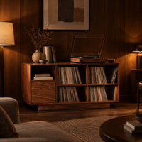 Low cabinet with a grid of open cubbies and a slim plinth base in an evening living room with walnut wall paneling