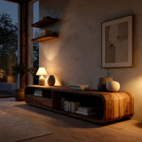 Rounded TV console with open bays and drawers in an evening room lit by two lamps