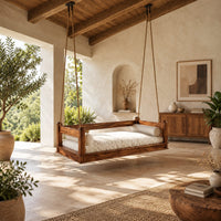 Hanging daybed swing with low wood rails and a thick seat pad in a bright open plan porch
