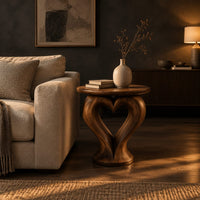 Round side table on a sculpted pedestal with a heart shaped opening in a dark living room at golden hour