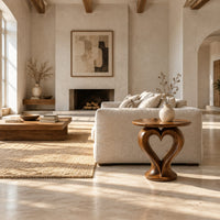 Round side table on a sculpted pedestal with a heart shaped opening in a bright open plan living room