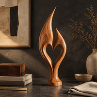 Corner detail of flame sculpture with two pointed tips enclosing a heart shaped opening beside wood, brass and linen samples