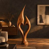 Flame sculpture with two pointed tips enclosing a heart shaped opening in a dark living room at golden hour