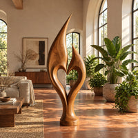 Flame sculpture with two pointed tips enclosing a heart shaped opening in a bright living room with arched windows and plants
