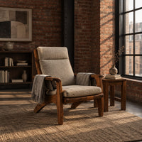 High back lounge chair with cushioned seat and sweeping wood arms in an industrial loft living room with exposed brick