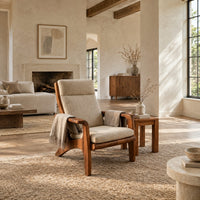 High back lounge chair with cushioned seat and sweeping wood arms in a bright open plan living room