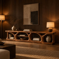 Long low media console with hollowed arch openings and open shelf bays in an evening living room with walnut wall paneling