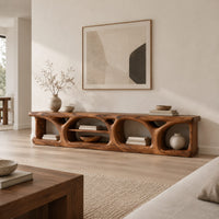 Long low media console with hollowed arch openings and open shelf bays in a Scandinavian living room with white walls