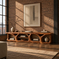 Long low media console with hollowed arch openings and open shelf bays in an industrial loft living room with exposed brick
