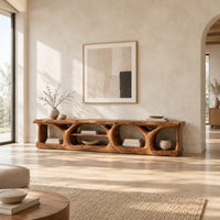 Long low media console with hollowed arch openings and open shelf bays in a bright open plan living room