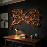 Honey toned tree web carved wall art above a desk in a dark study corner