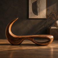 Sculpted bench with a hooked back and an open loop base, three-quarter view showing the grain
