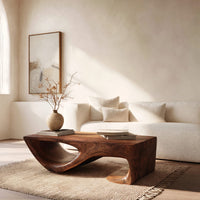 Dark coffee table with a scooped hollow and hooked end in an open plan space in daylight
