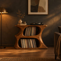 Hourglass record player stand with two stacked oval openings and a flat top in a dark living room at golden hour