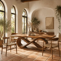 Dining table with a thick slab top on an infinity loop base in a bright dining room with arched windows and plants