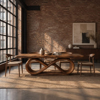 Dining table with a thick slab top on an infinity loop base in an industrial loft dining room with exposed brick