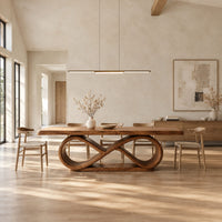 Dining table with a thick slab top on an infinity loop base in a bright open plan dining room