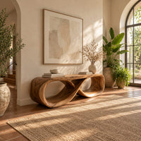 Low bench with a flat top and a hollow figure eight loop base in a bright entryway with arched windows and plants