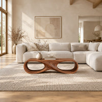 Coffee table shaped as an infinity loop with two oval openings in a bright open plan living room