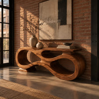 Console table shaped as an infinity loop with open ribbon spaces in an industrial loft entryway with exposed brick