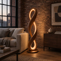 Twisted infinity loop floor lamp with a glowing inner edge in an industrial loft living room with exposed brick
