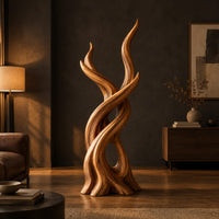 Interlaced branch sculpture with flame shaped tips and an open hollow near the base in a dark living room at golden hour