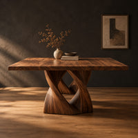 Rectangular dining table on a single pedestal of interlocking twisted ribbons in a dark studio against a charcoal plaster wall