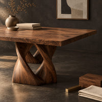 Corner detail of rectangular dining table on a single pedestal of interlocking twisted ribbons beside wood, brass and linen samples